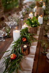 Banquet decoration in a simple rustic style with grass, greenery, simple objects and fabrics. Wedding table setting for guests