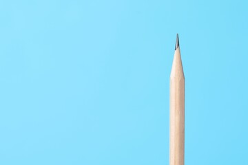 One graphite pencil on light blue background, closeup. Space for text