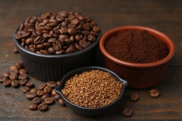 Different types of instant coffee and beans in bowls on wooden table, closeup