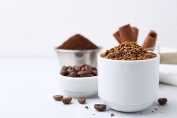 Granulated instant coffee and beans on light table, selective focus. Space for text
