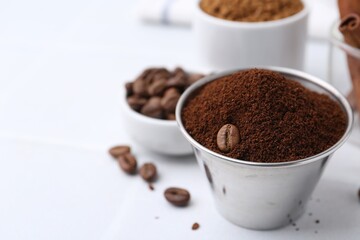 Instant coffee powder and beans on light table, selective focus. Space for text