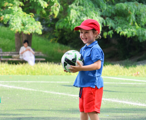  little three-year-old boy plays football at a sports school.