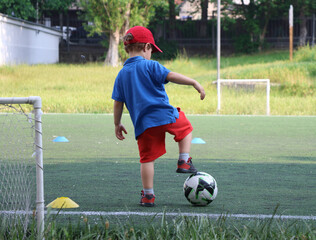  little three-year-old boy plays football at a sports school.