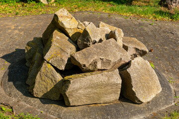 Natural stone arrangement surrounded by green grass and sunlight in a tranquil outdoor setting