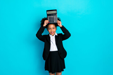 Young schoolgirl holding a calculator on her head, dressed in a formal suit, posing confidently...