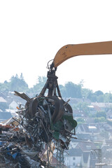 Hydraulikkran hebt Altmetall auf dem Schrottplatz