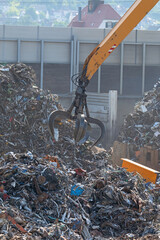 Obraz premium Hydraulikkran hebt Altmetall auf dem Schrottplatz