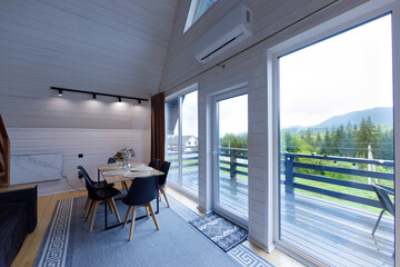 Cozy Modern Dining Space with Scenic Views in a Charming Mountain Getaway Featuring Large Windows to Bring the Outdoors In and Inviting Interior Decor for a Relaxing Atmosphere