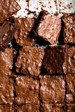 An overhead view of freshly baked chocolate brownies cut into squares.