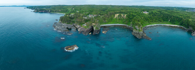 石川県能登の海岸風景をパノラマで空撮。巌門に向かう遊覧船の姿を含み、観光PRや地域紹介素材としても使える、ストーリー性ある写真です。