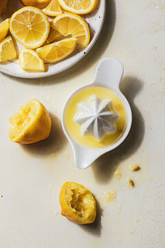 Juicer and squeezed lemons with juice and seeds on countertop-overhead.jpg