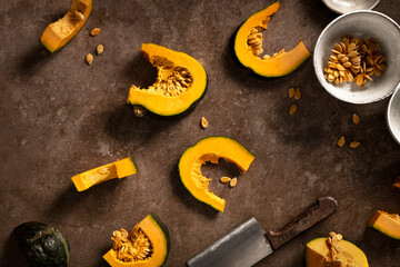 sliced delica pumpkin on brown table, seeded with kitchen knife