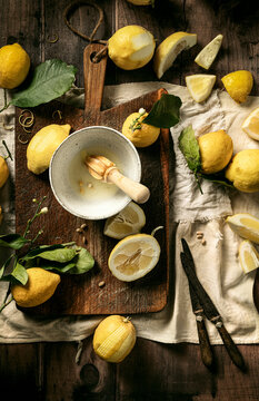 fresh lemons just squeezed on wooden board with leaves