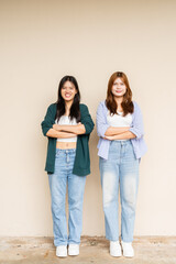 Obraz premium portrait of two teenage girls with arms crossed looking at camera smiling