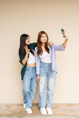 two young women taking selfie with smartphone