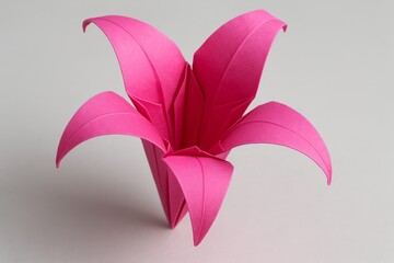 Elegant pink origami flower crafted from paper showcasing intricate folds and a vibrant design
