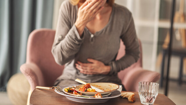 Woman with bloating and stomach pain after eating