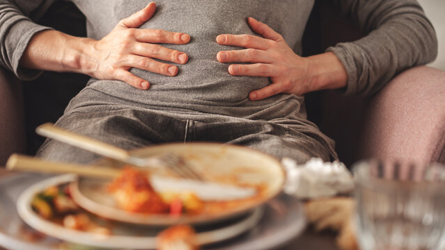 Woman with bloating and stomach pain after eating