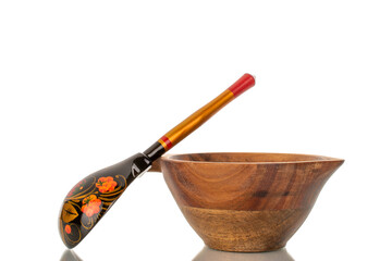 One painted wooden spoon with wooden cup isolated on white background, close-up.
