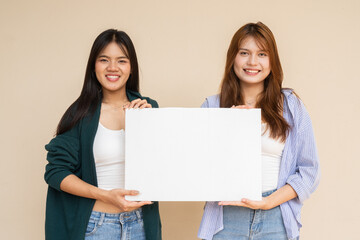 two young women holding blank white board