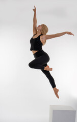 Dancer Toni in the studio dancing Dancer Toni in the studio dancing with motion and light - The image depicts a dancer captured mid-air in a striking pose. They are dressed in a black tank top and bla
