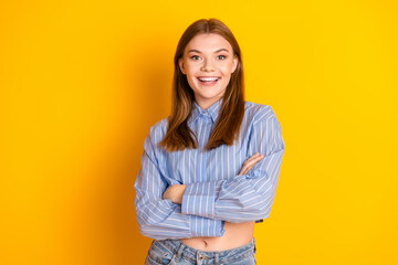 Young woman with brown hair smiling confidently in a casual striped blue shirt against a vibrant...
