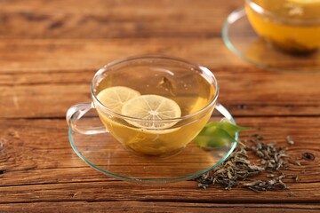 Cup of tasty green tea with lemon on wooden table, closeup