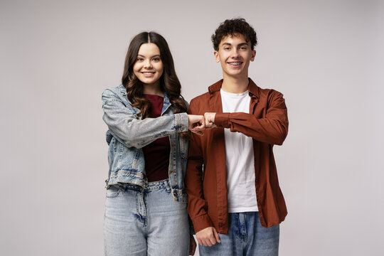 Two happy teenagers bumping fists celebrating success