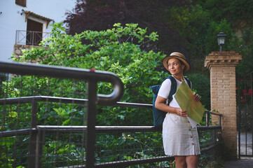 Young Woman Tourist Exploring a Charming Old Town with Map and Backpack