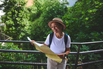 Woman Exploring Nature with a Map, Wearing a Hat and Backpack