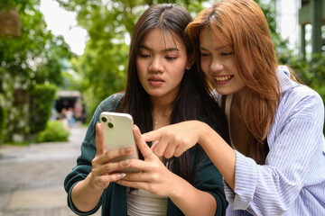 Fototapeta premium young couple using smartphone in the park