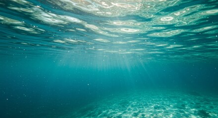 Serene underwater scene with sunlight filtering through turquoise ocean surface