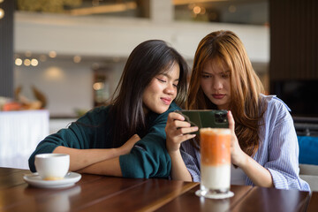 two young women drinking coffee in cafe