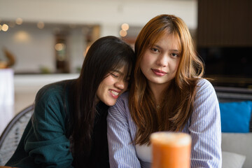 Fototapeta premium Young happy lesbian LGTB couple in cafe smiling