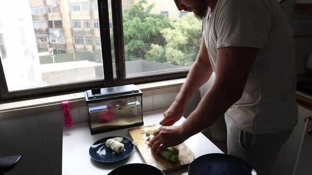 Chef slicing fresh leeks on wooden cutting board