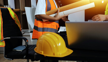 Closeup of team of industrial engineers meeting analyze machinery blueprints consult project on...