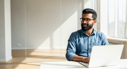 Professional man working on laptop in modern office business environment creative workspace bright and minimalistic focused perspective