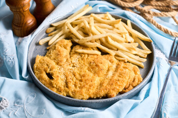 Plate of beef milanesa, cotoletta or schnitzel with side fries