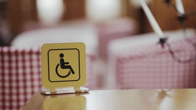 Yellow wheelchair accessibility sign in a cozy restaurant setting