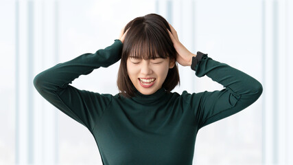 頭を抱えて困る若い女性・ビジネスウーマン