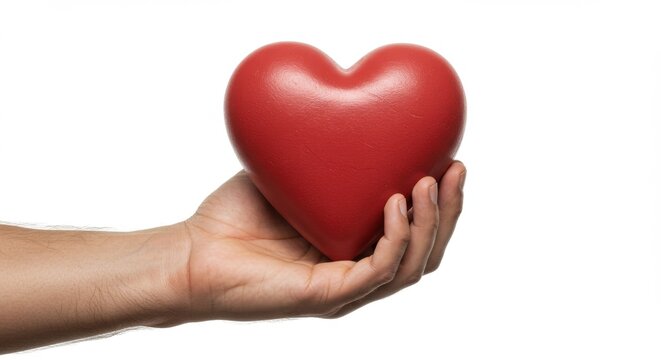 Naklejki Close-up of a hand holding a soft red heart, symbolizing love and affection