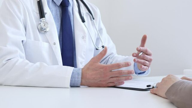 Doctor gesturing with hands while explaining diagnosis to patient during medical consultation in hospital office, healthcare and medical concept. Medicine - Powered by Adobe