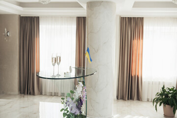 Elegant reception setup with glasses and Ukrainian flag in a bright venue