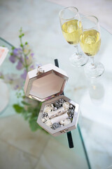 A hexagonal box displays an assortment of jewelry next to sparkling beverages