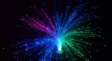 Naklejka premium Vibrant, multicolored optical fibers radiate outward against a stark black background, creating a dazzling light display