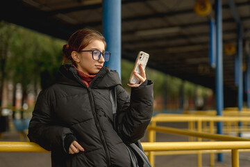 Girl Waiting For A Bus At The Station In Spring
