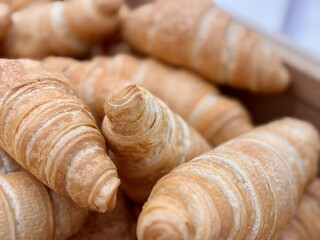 A delightful stack of warm, freshly baked, golden croissants is beautifully arranged. An enticing tower of perfectly baked golden croissants, showcasing their flaky and delightful texture beautifully