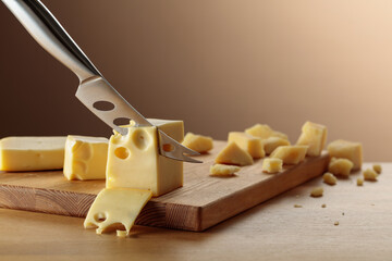 Cheese and knife on a wooden cutting board.