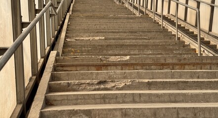 Fototapeta premium Weathered Concrete Steps Found in an Urban Environment and City Life Above and Below. An image showcasing worn concrete steps that reflect years of intense use and weathering in a public space