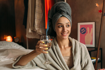 Smiling woman drinking water after party at home